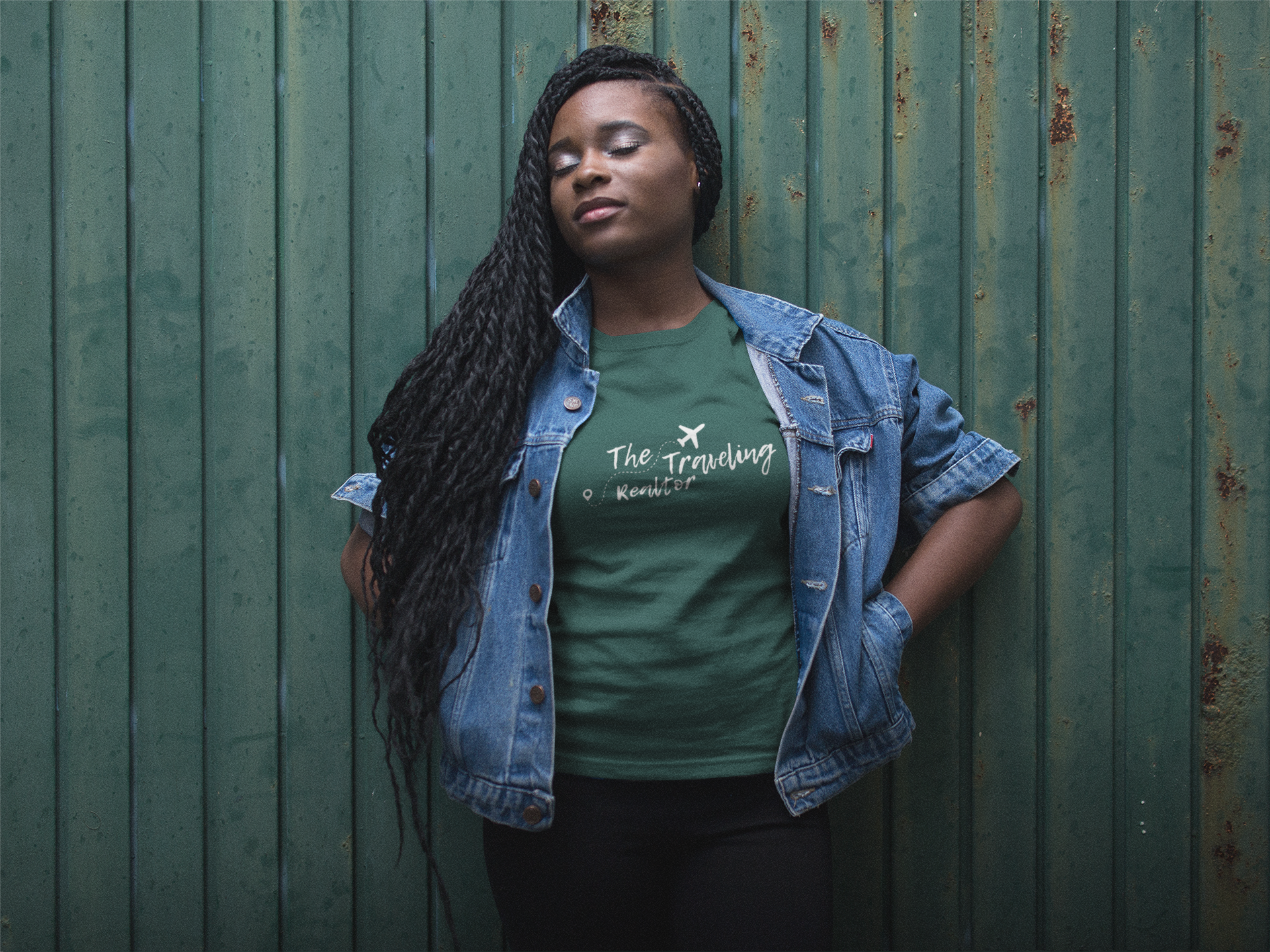 Woman wearing The Traveling Realtor branded green t-shirt styled casually against a textured green wall representing lifestyle brand application